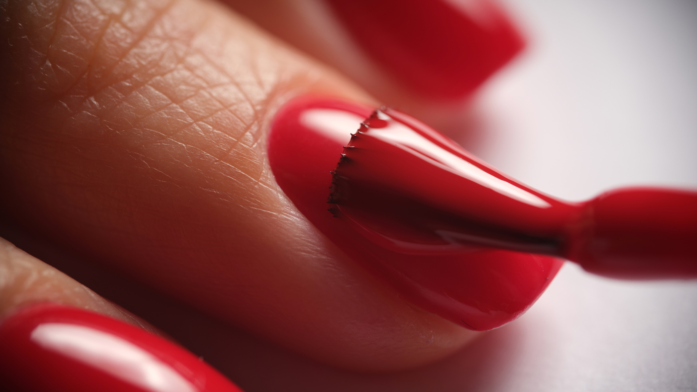Manicurist Paints Nails with Red Gel Polish Closeup